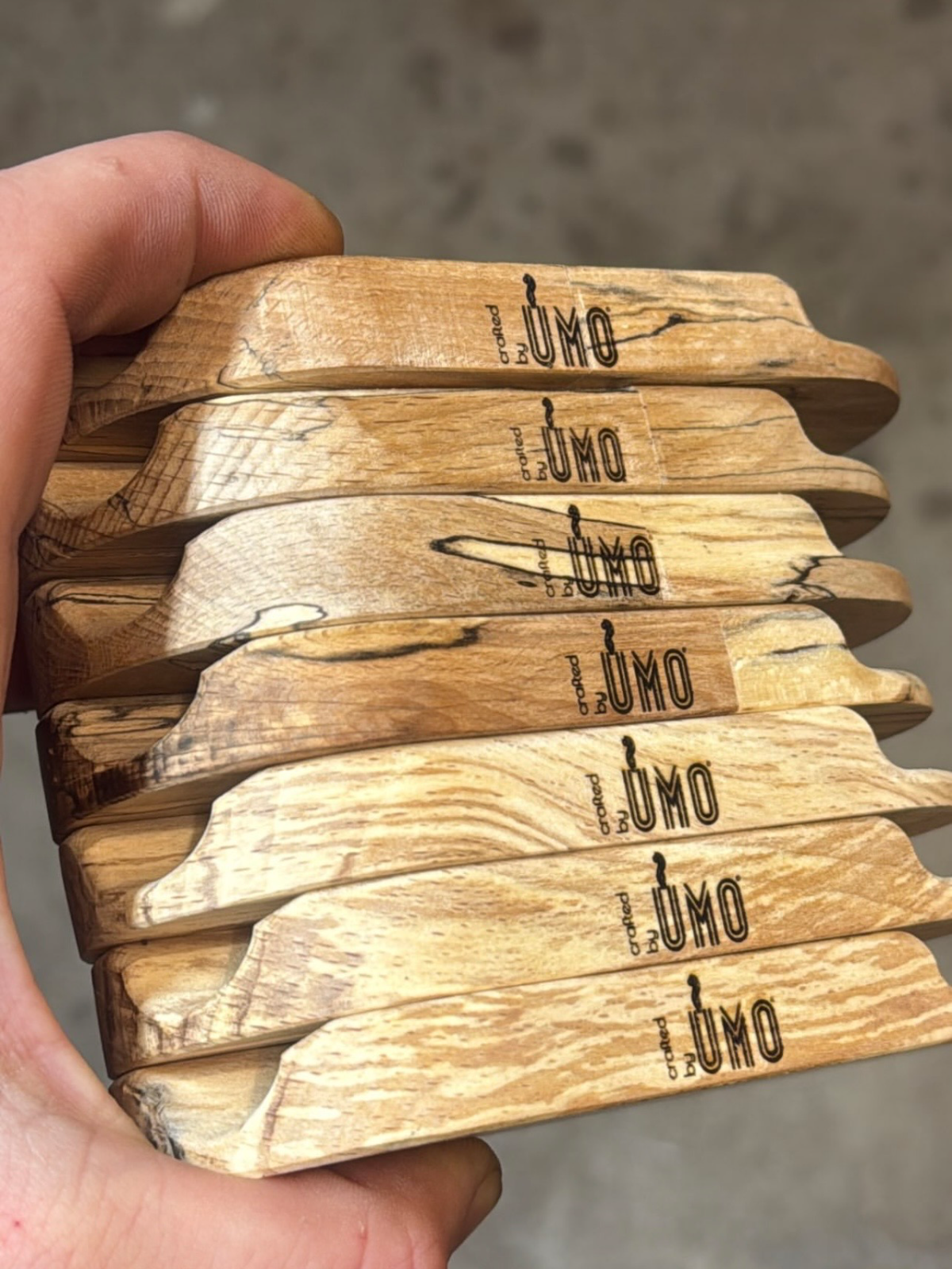 A stack of Doink Rolling Station trays in spalted beech wood featuring dark grain lines and a branded black logo.